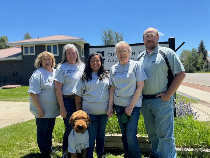 A group of people and a dog are posing for a picture in front of a building.