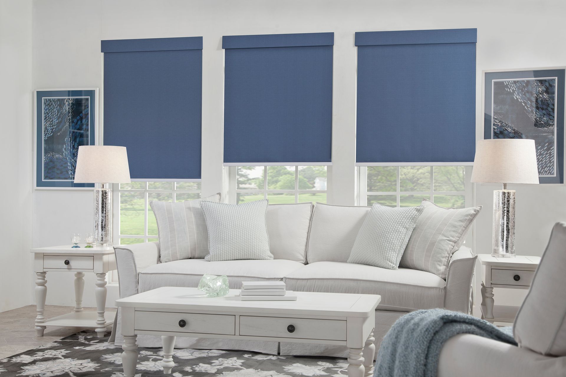 Windows with white and blue layered blinds, against a white wall.