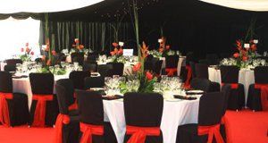 Wedding breakfast with black chair covers with red ribbons