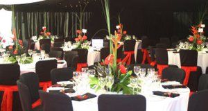 Wedding breakfast with black chair covers with red ribbons