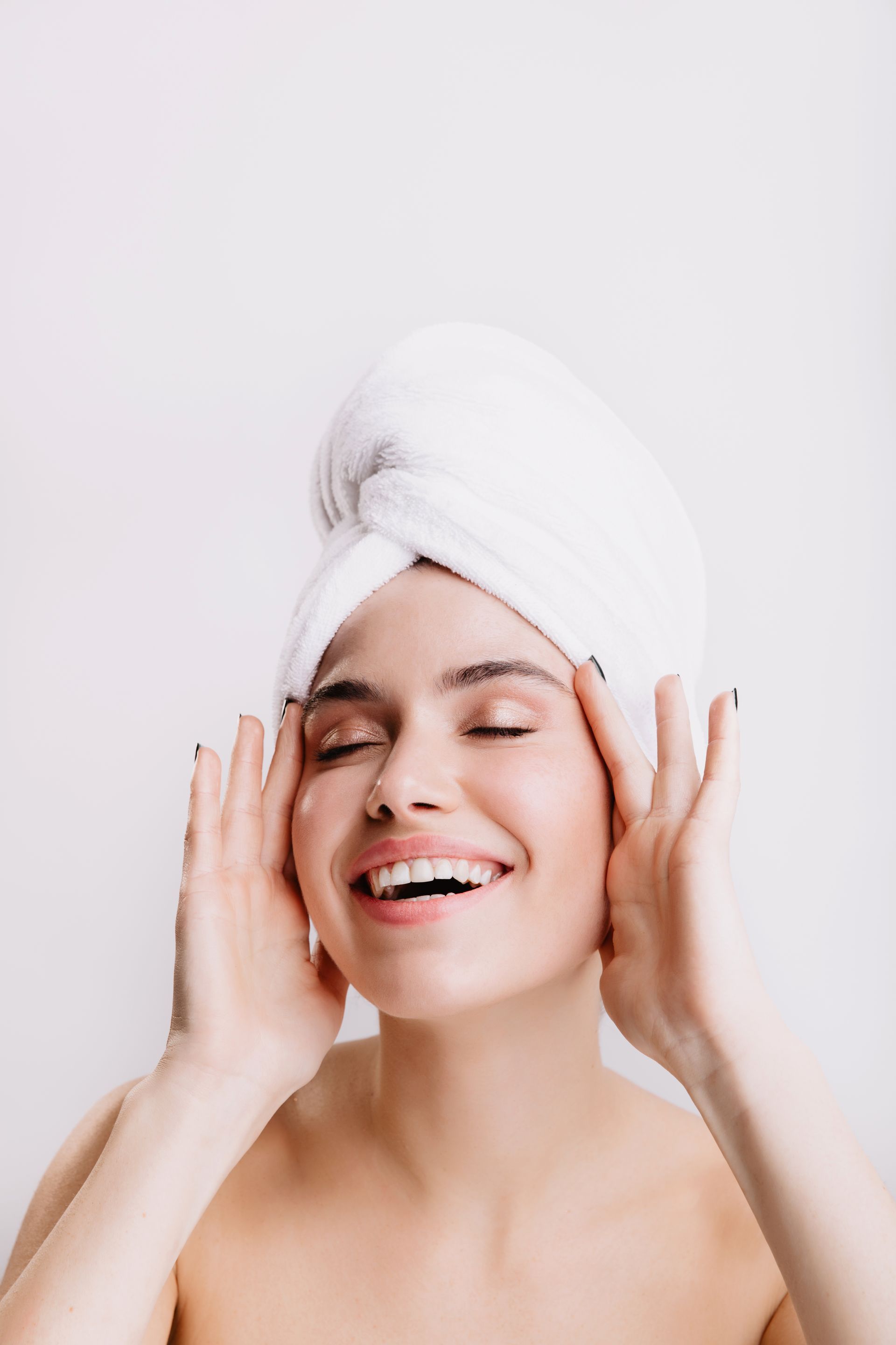 a woman with a towel wrapped around her head is smiling
