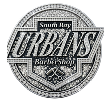 Logo for South Bay Urbans BarberShop featuring bold text and a scissor icon, decorated in a silver, diamond-like style.