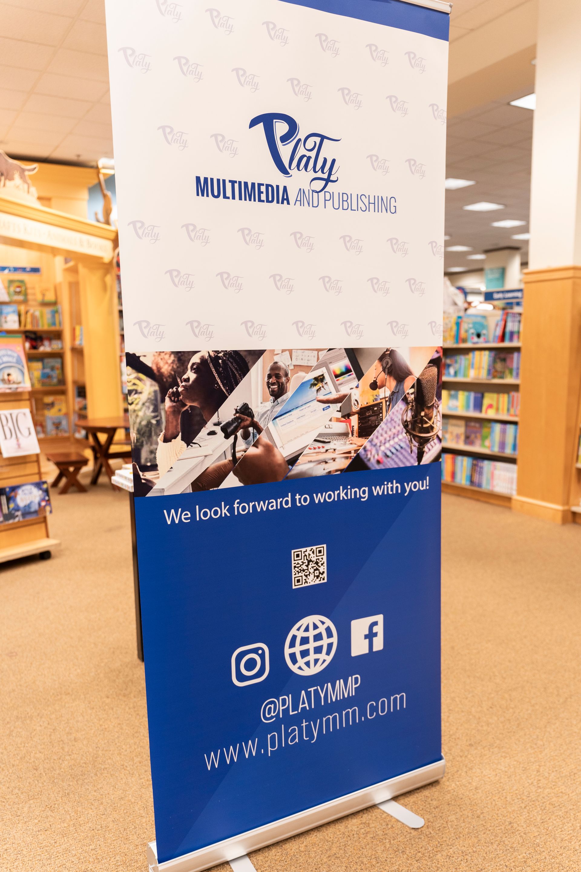 A blue and white banner is sitting in a bookstore.