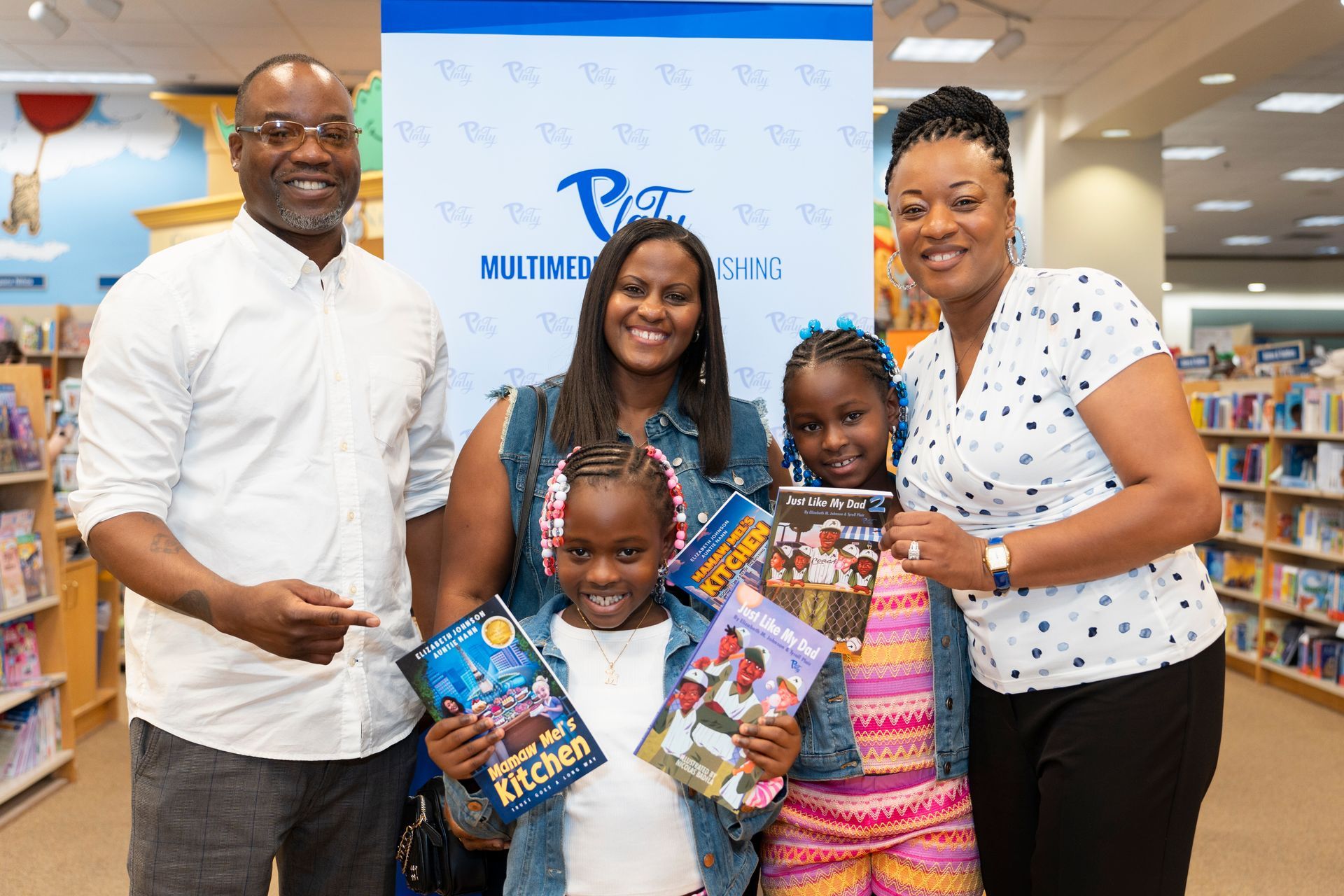 A family is posing for a picture in a bookstore holding books.