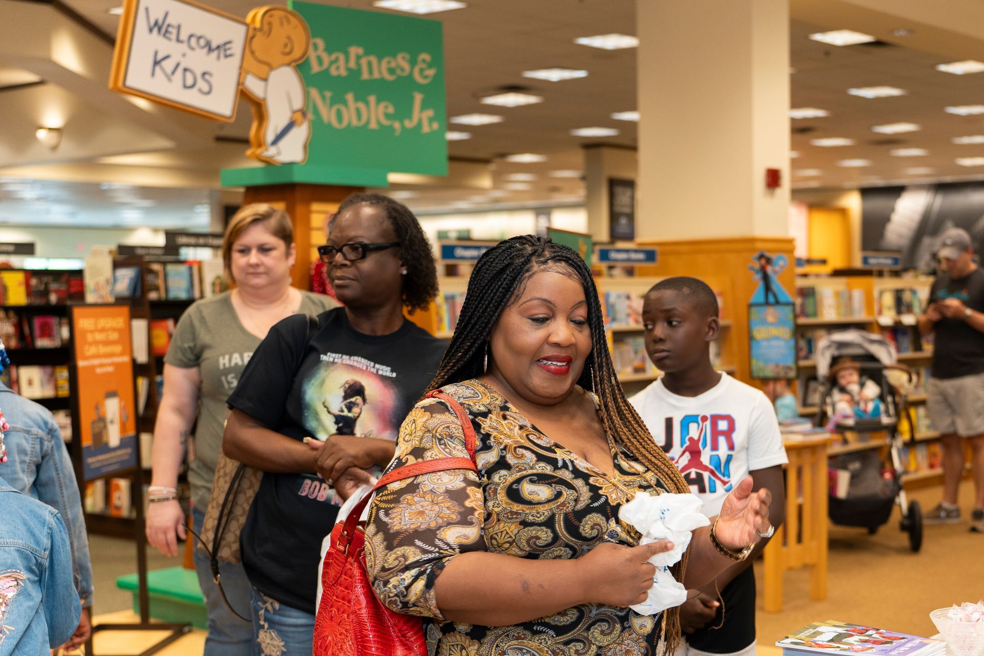 A group of people are standing in a bookstore.