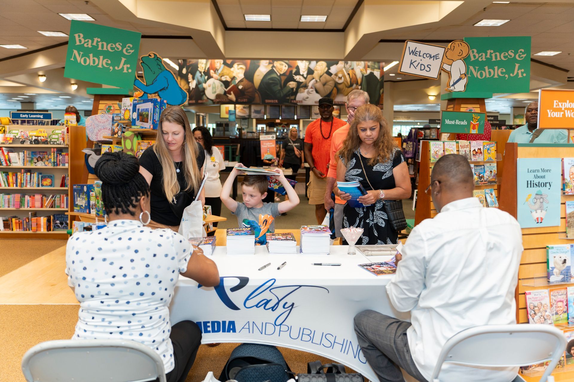 A group of people are sitting at a table in a bookstore.