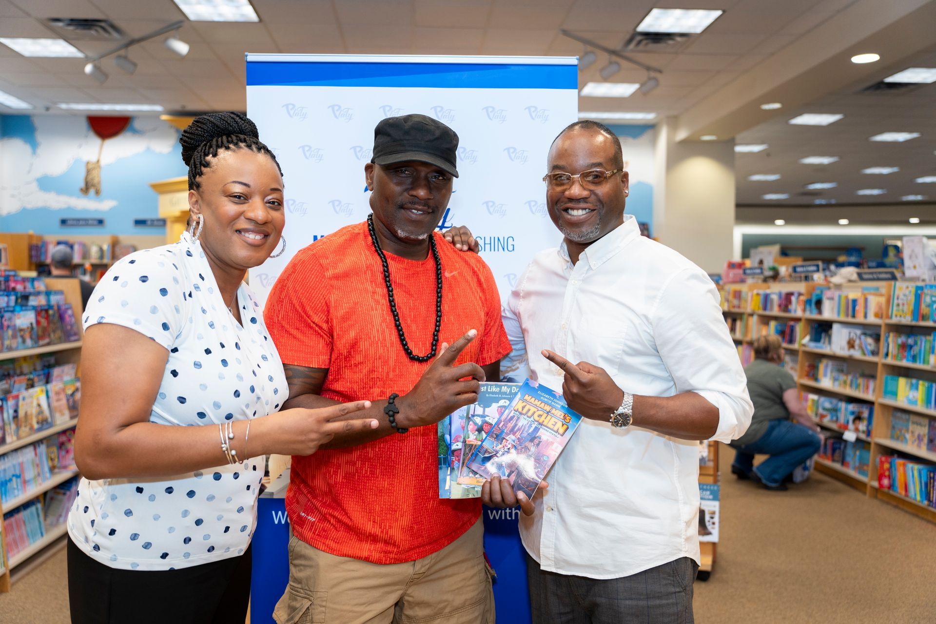 Three people are posing for a picture in a bookstore.