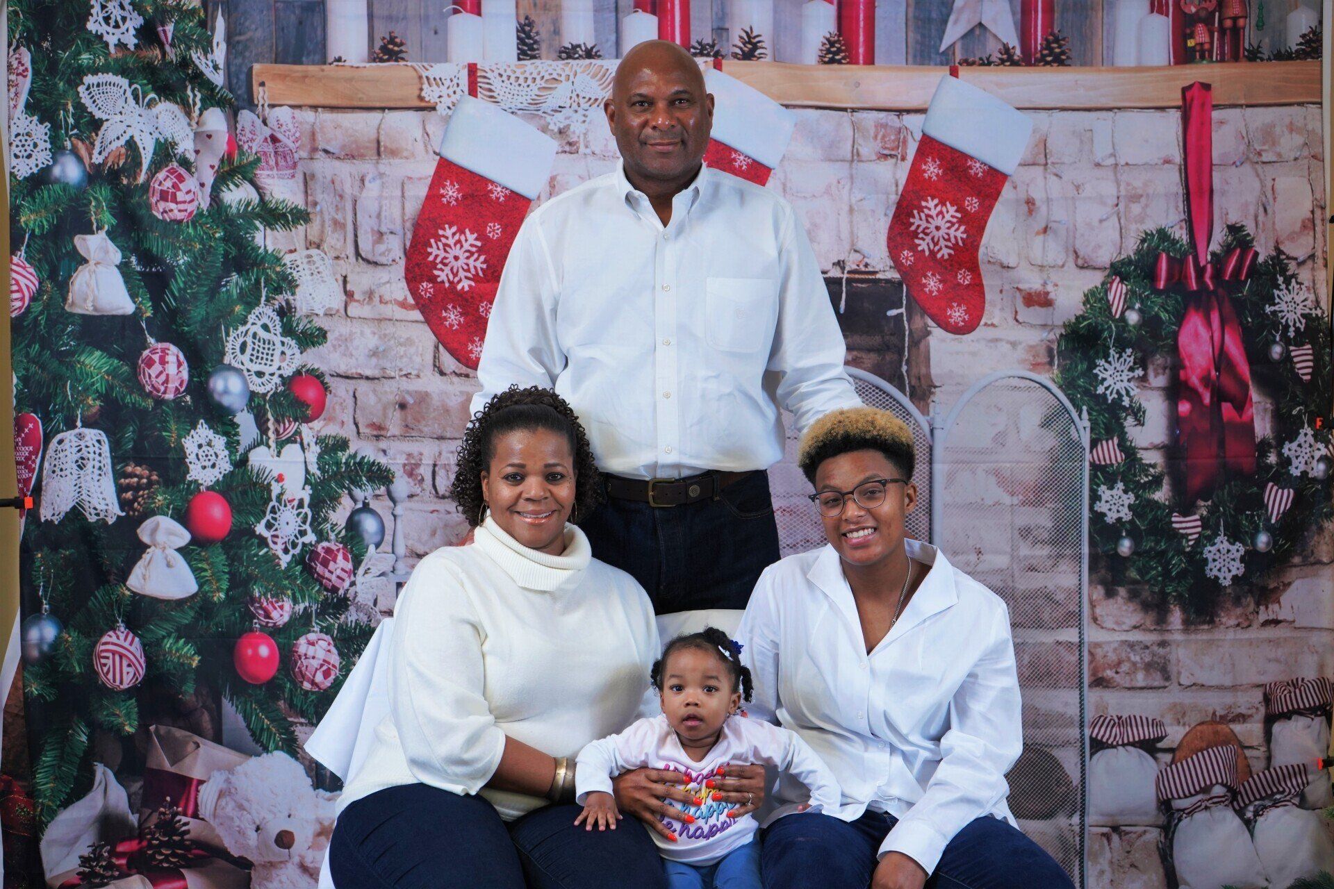 A family is posing for a picture in front of a christmas tree.
