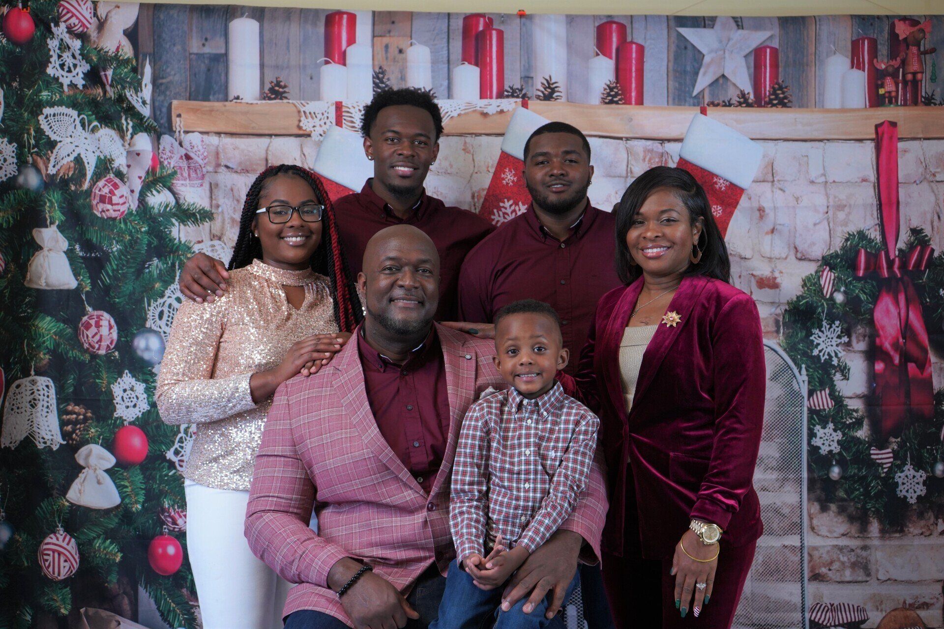 A family is posing for a picture in front of a christmas tree.
