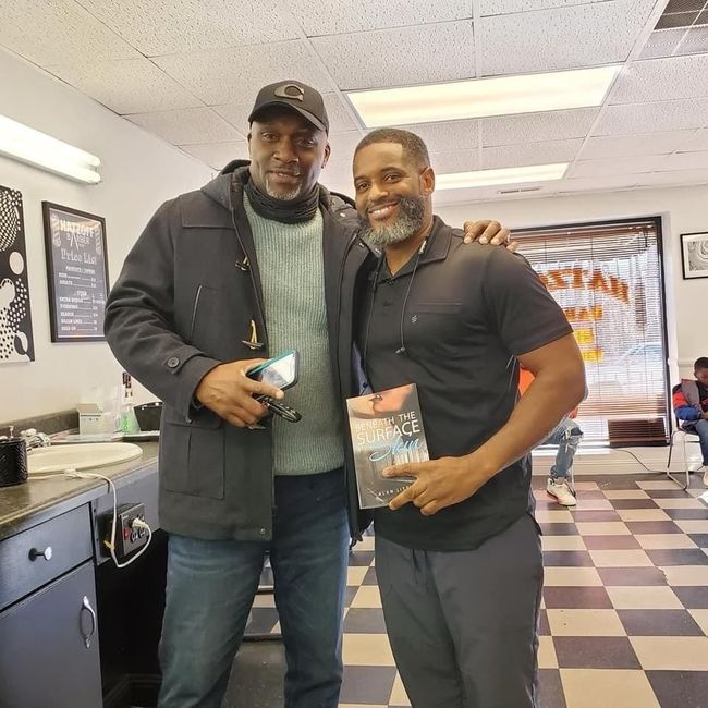 Two men are posing for a picture in a barber shop