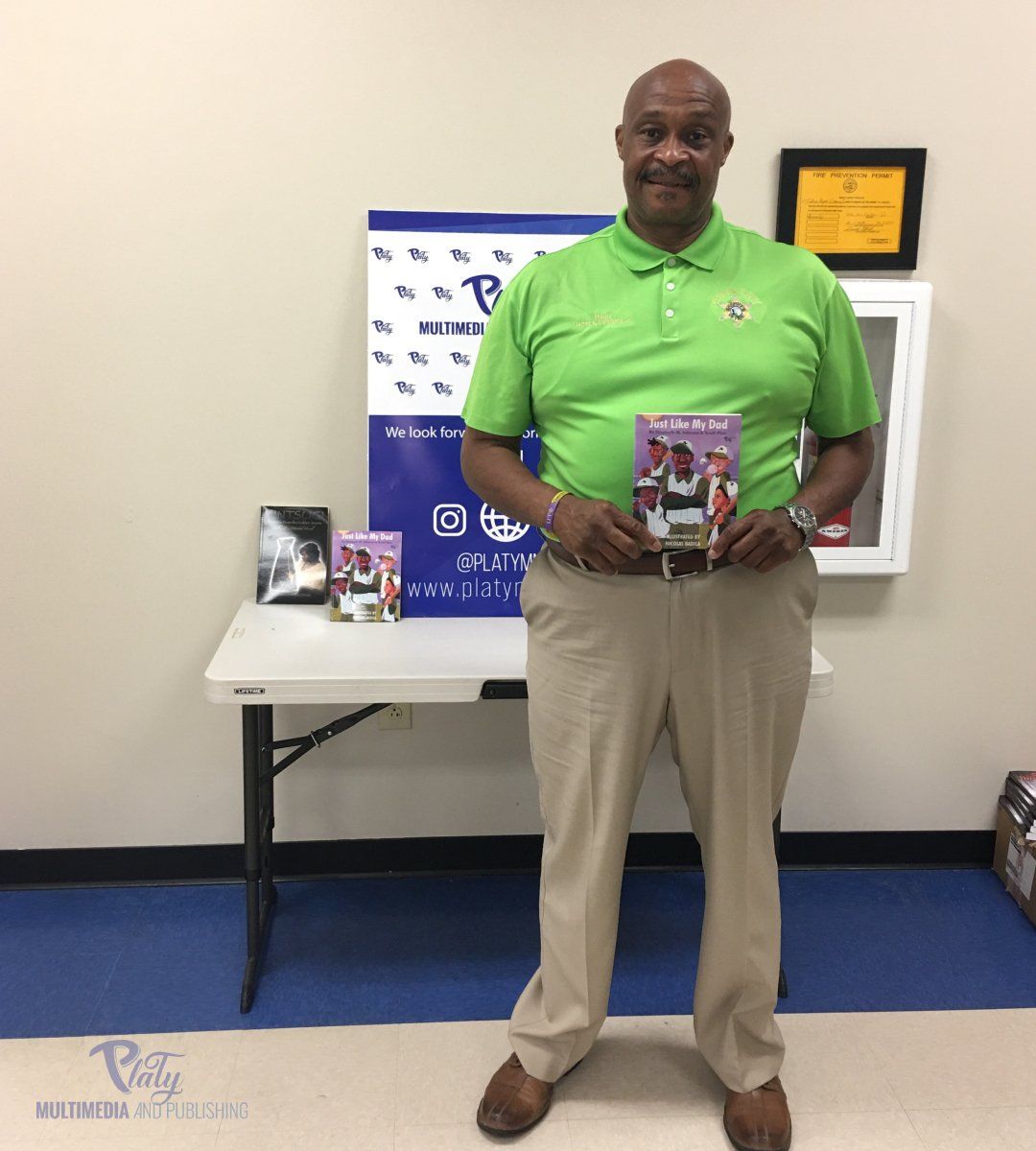A man in a green shirt is holding a book