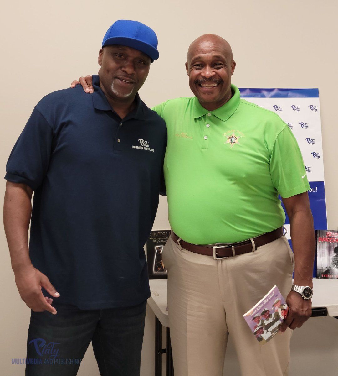Two men posing for a picture with one wearing a green shirt