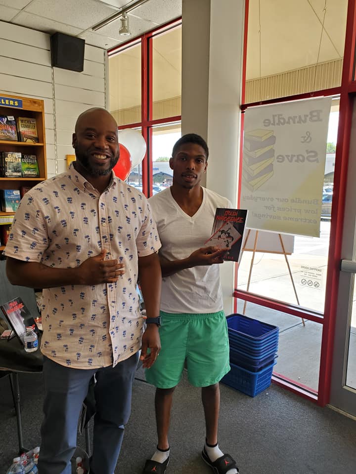Two men are standing next to each other in a store holding books.