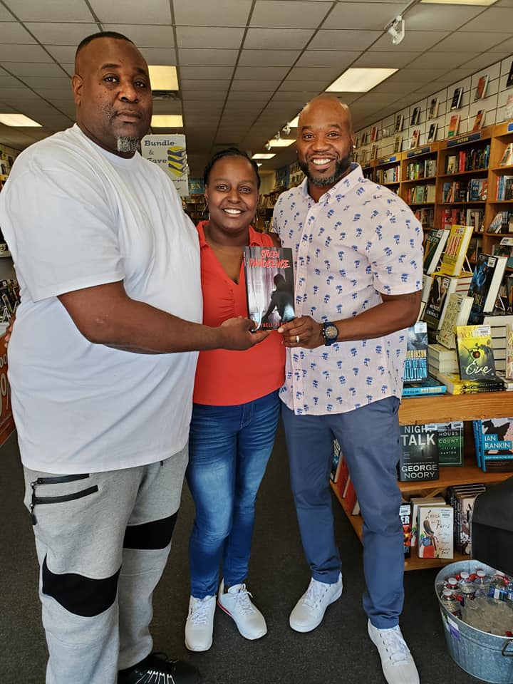 A man is giving a book to a woman in a bookstore.