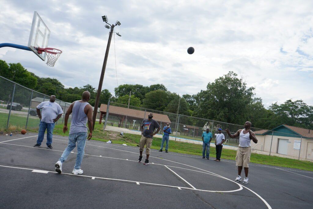 A group of people are playing basketball on a court