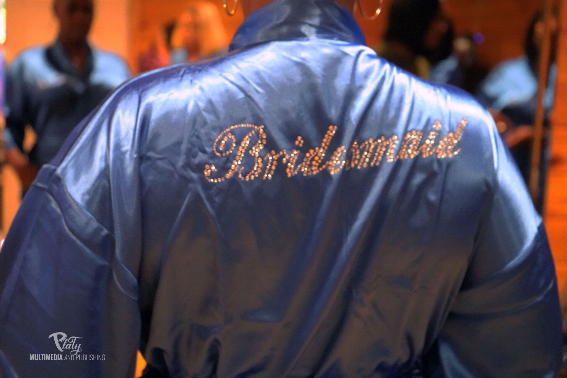 A blue robe with the word bridesmaid on it