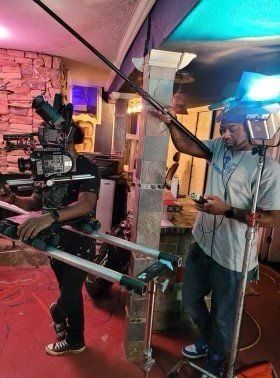 A man is standing in front of a camera in a room.