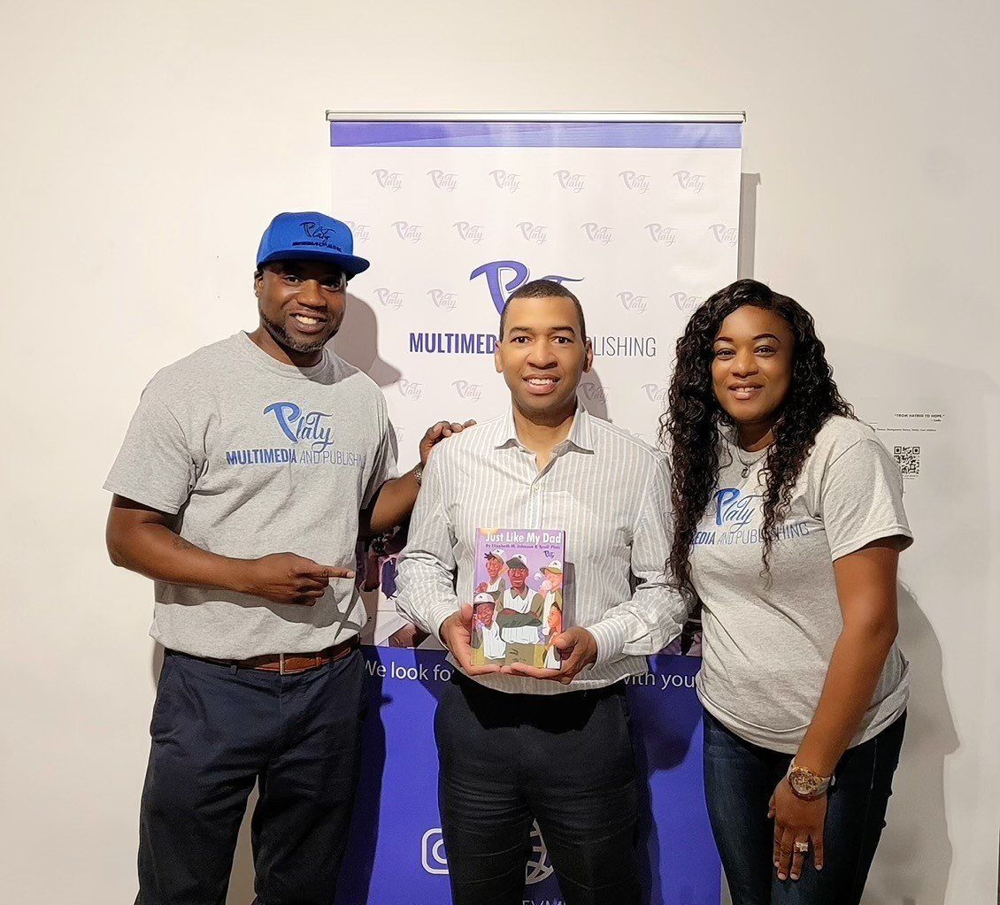 Three people are posing for a picture in front of a banner.