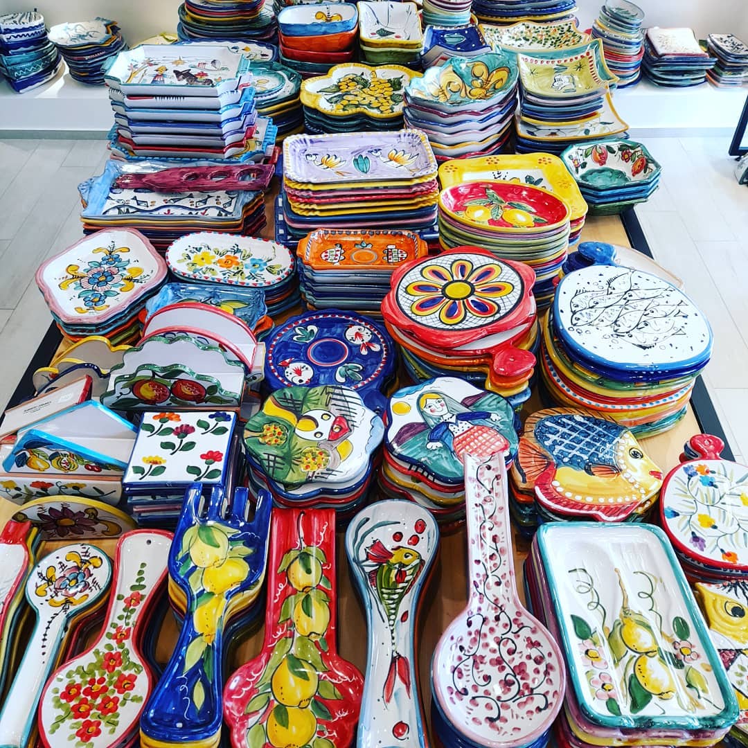 In vendita piatti e utensili in ceramica colorati, con motivi floreali e di frutta.