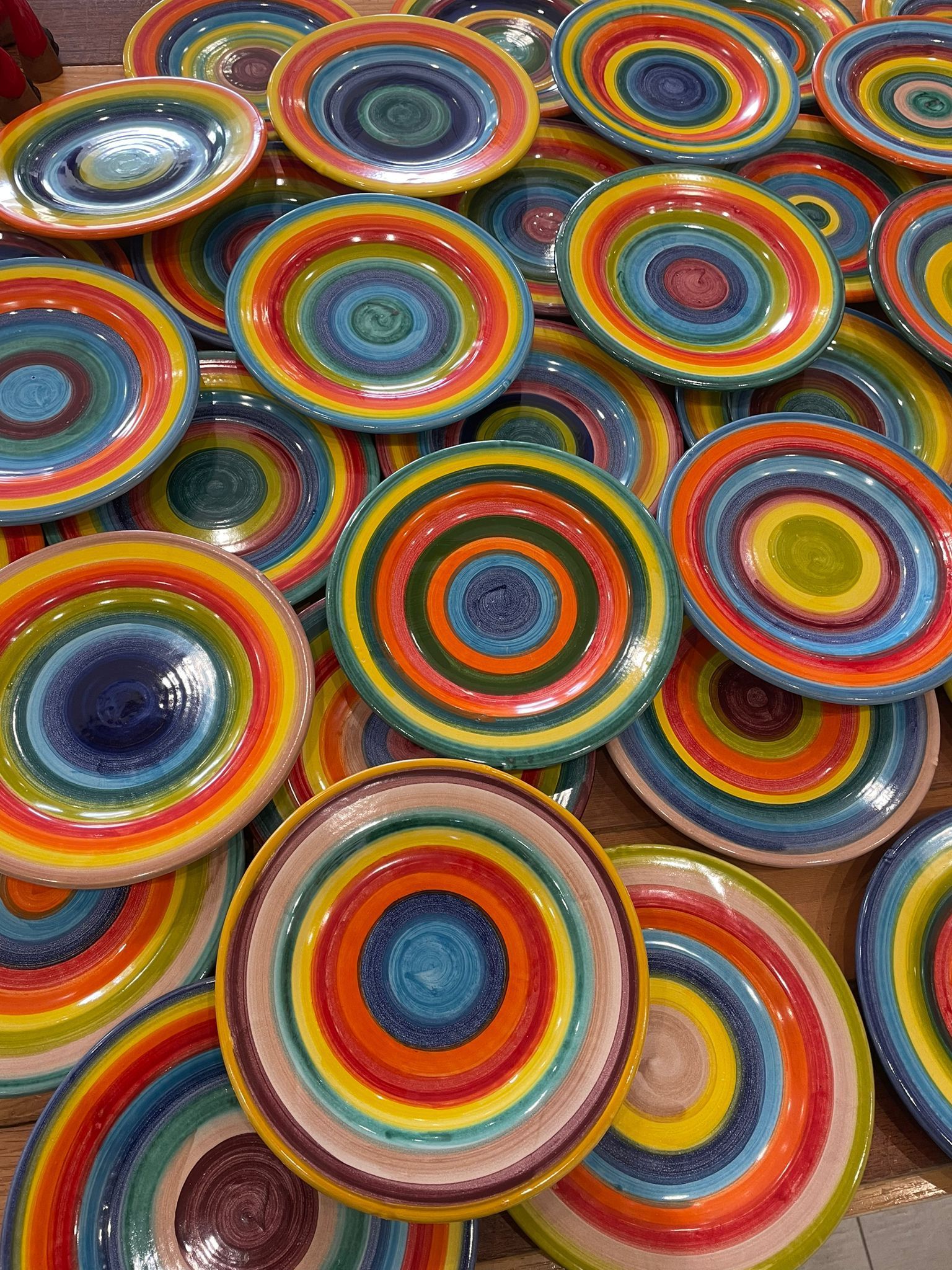 Piatti di ceramica colorati disposti insieme, che mostrano cerchi concentrici di varie tonalità.