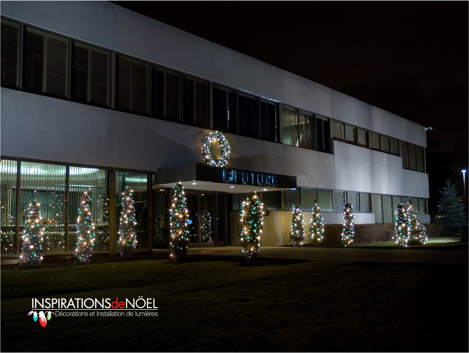 A large building with christmas trees in front of it
