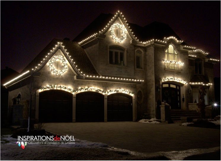 A large house is decorated with christmas lights and wreaths
