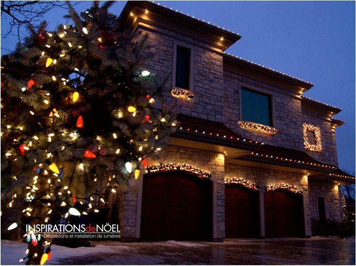 A house decorated for christmas with a christmas tree in front of it