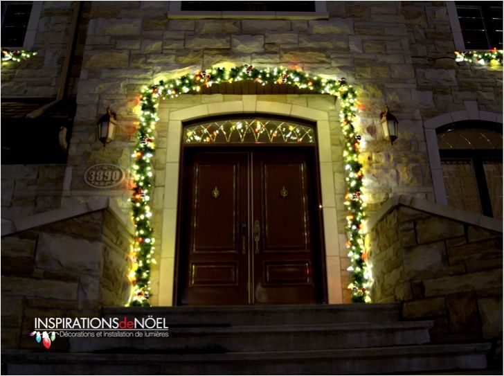 The front door of a building is decorated with christmas lights