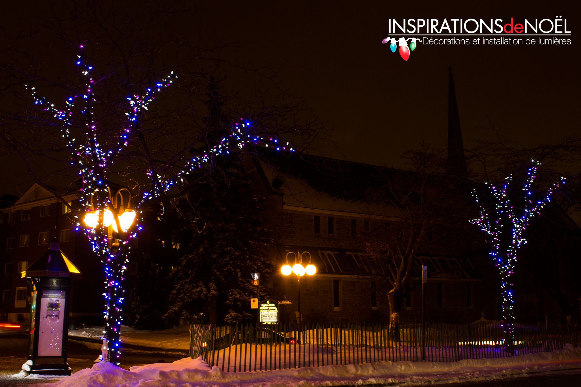 Two trees are decorated with blue lights and the words inspirations de noel on the bottom
