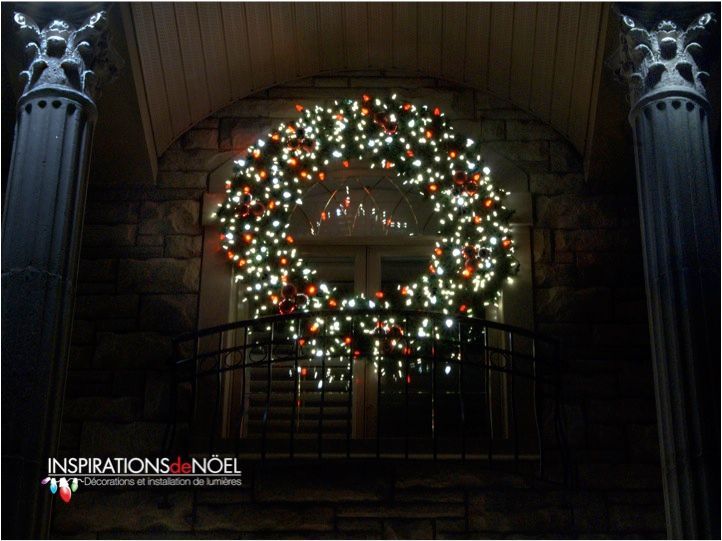 A christmas wreath hanging on a balcony with inspirations noel written on the bottom