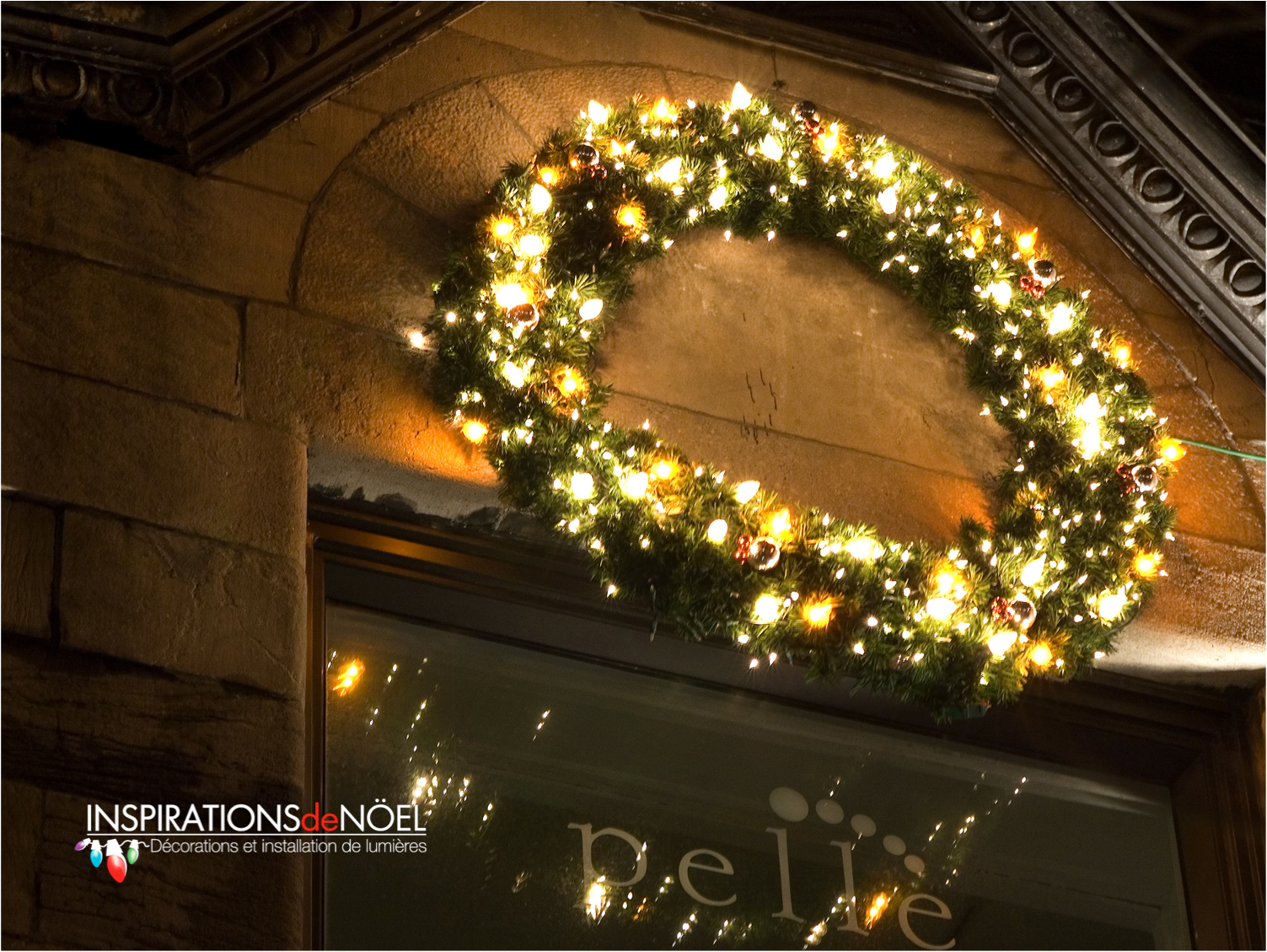 A christmas wreath is hanging on the side of a building