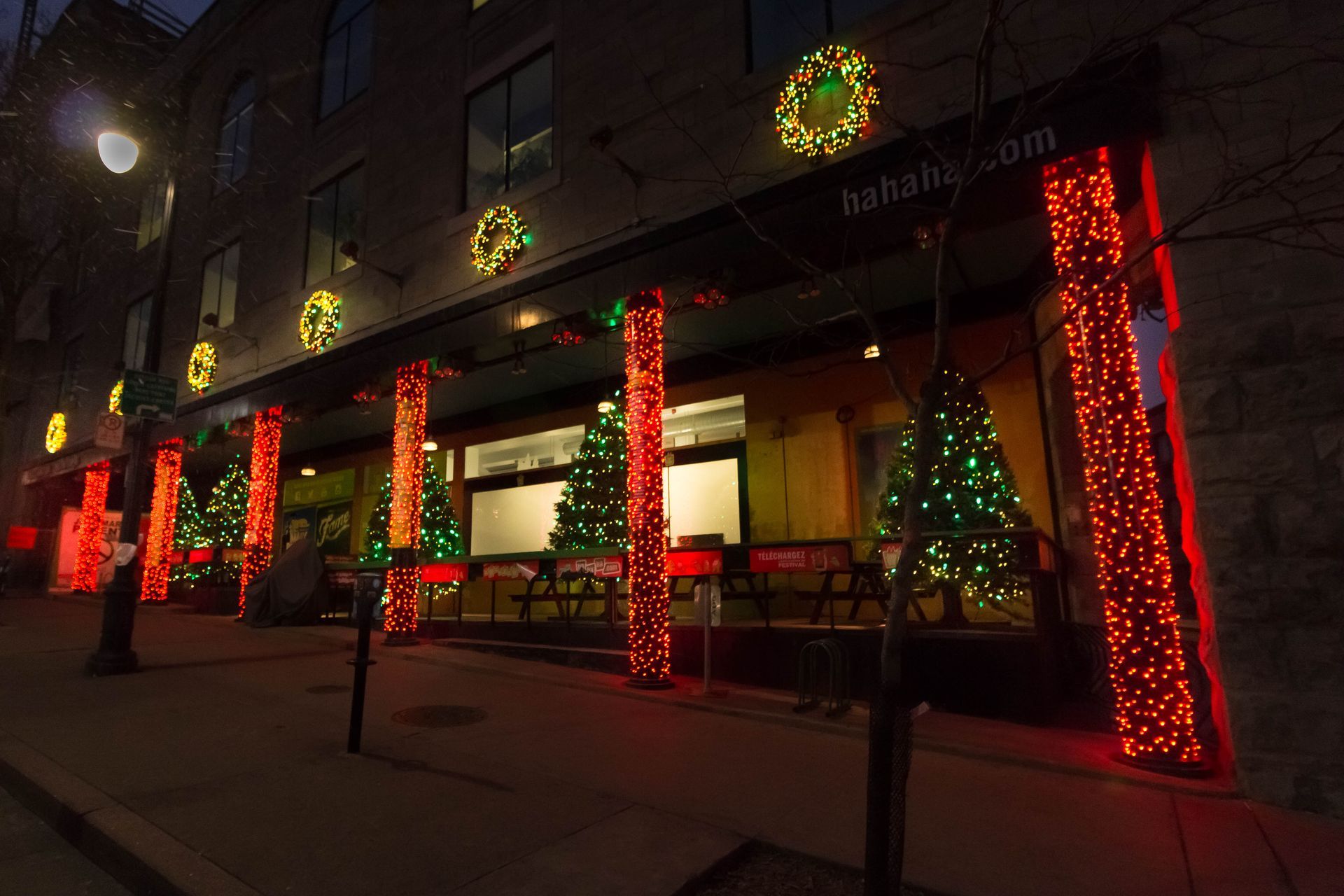 A building with christmas lights on it is lit up at night.