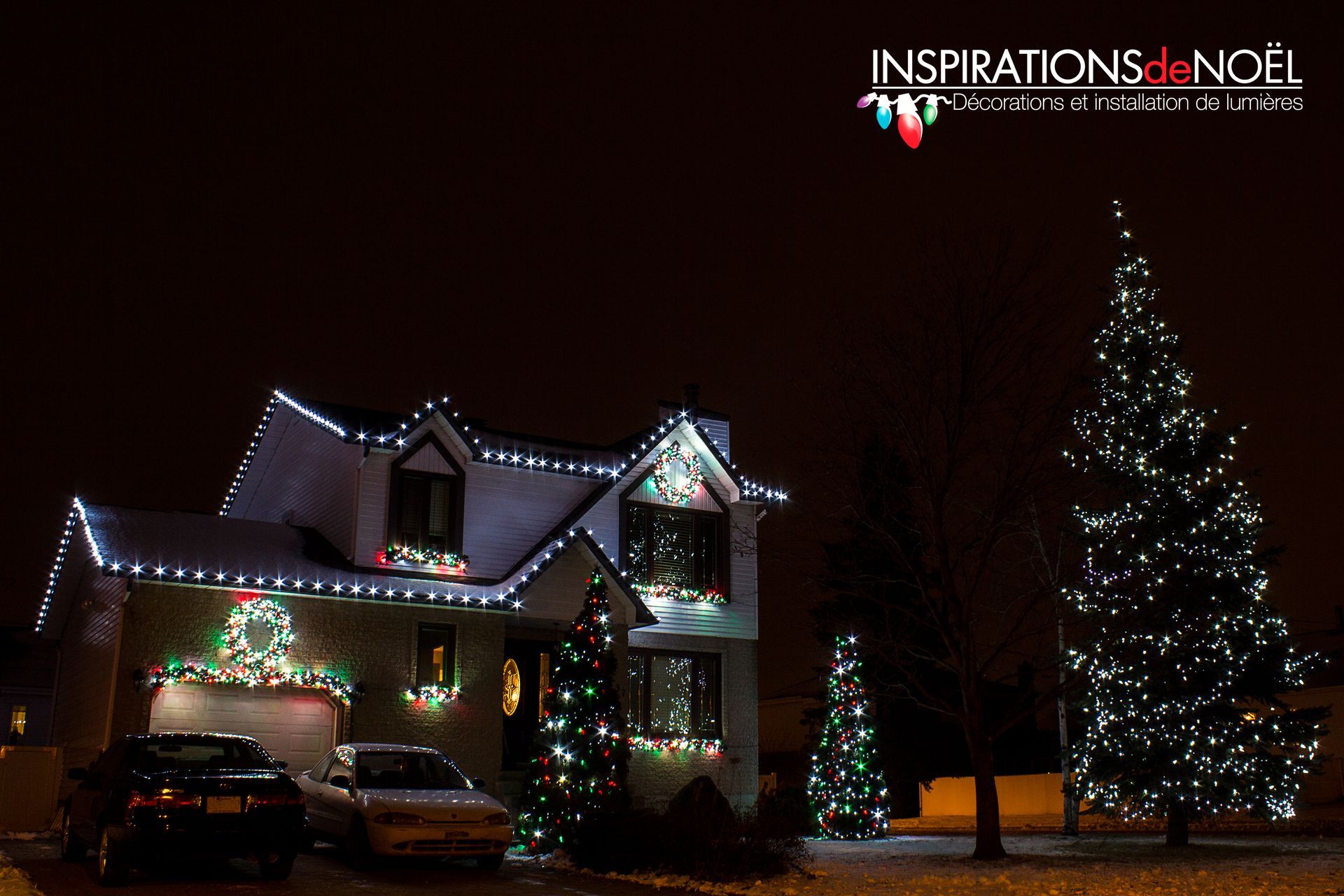 A house is decorated with christmas lights and a car is parked in front of it