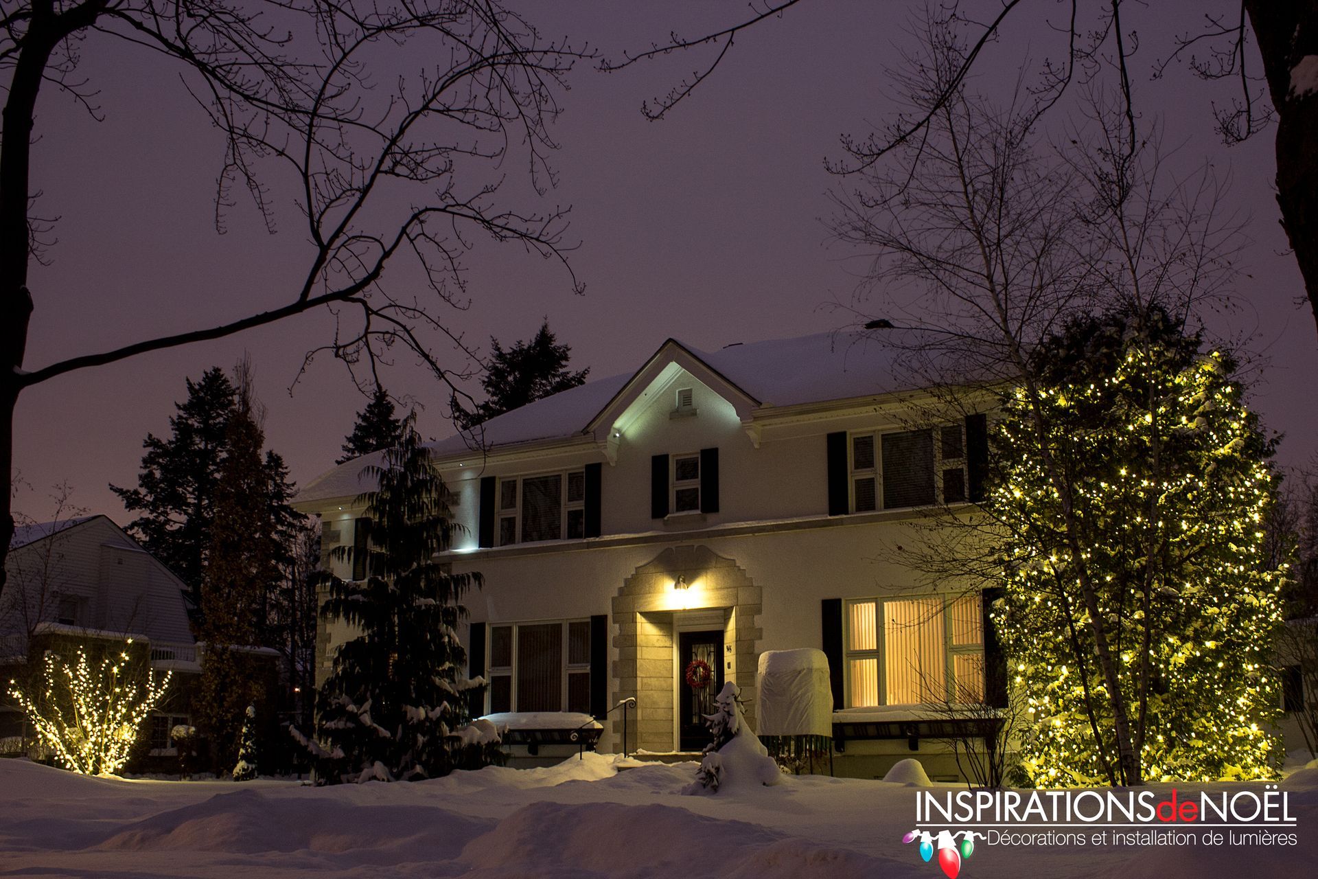 A house is decorated with christmas lights and snow