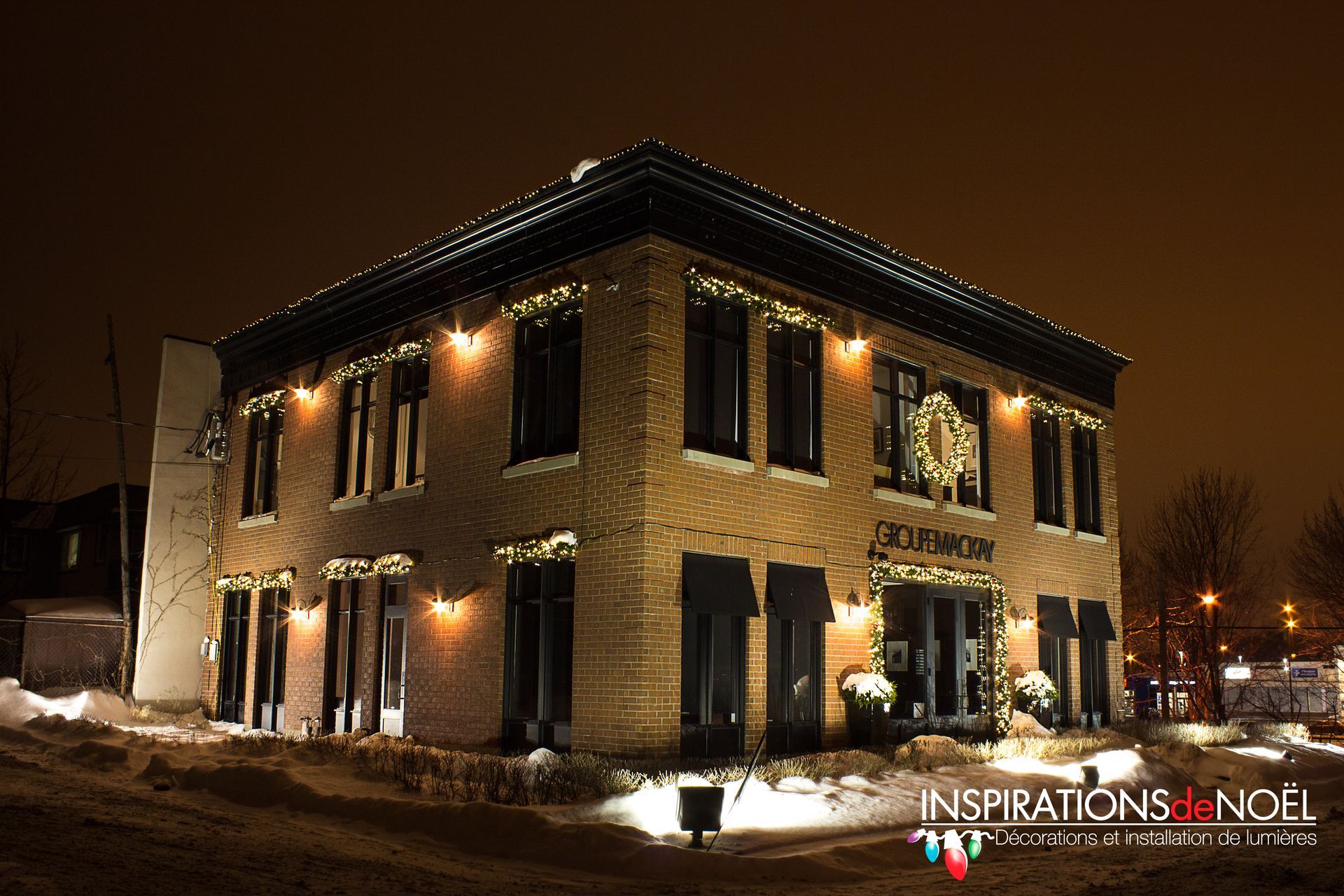 A large building with christmas lights on it is lit up at night