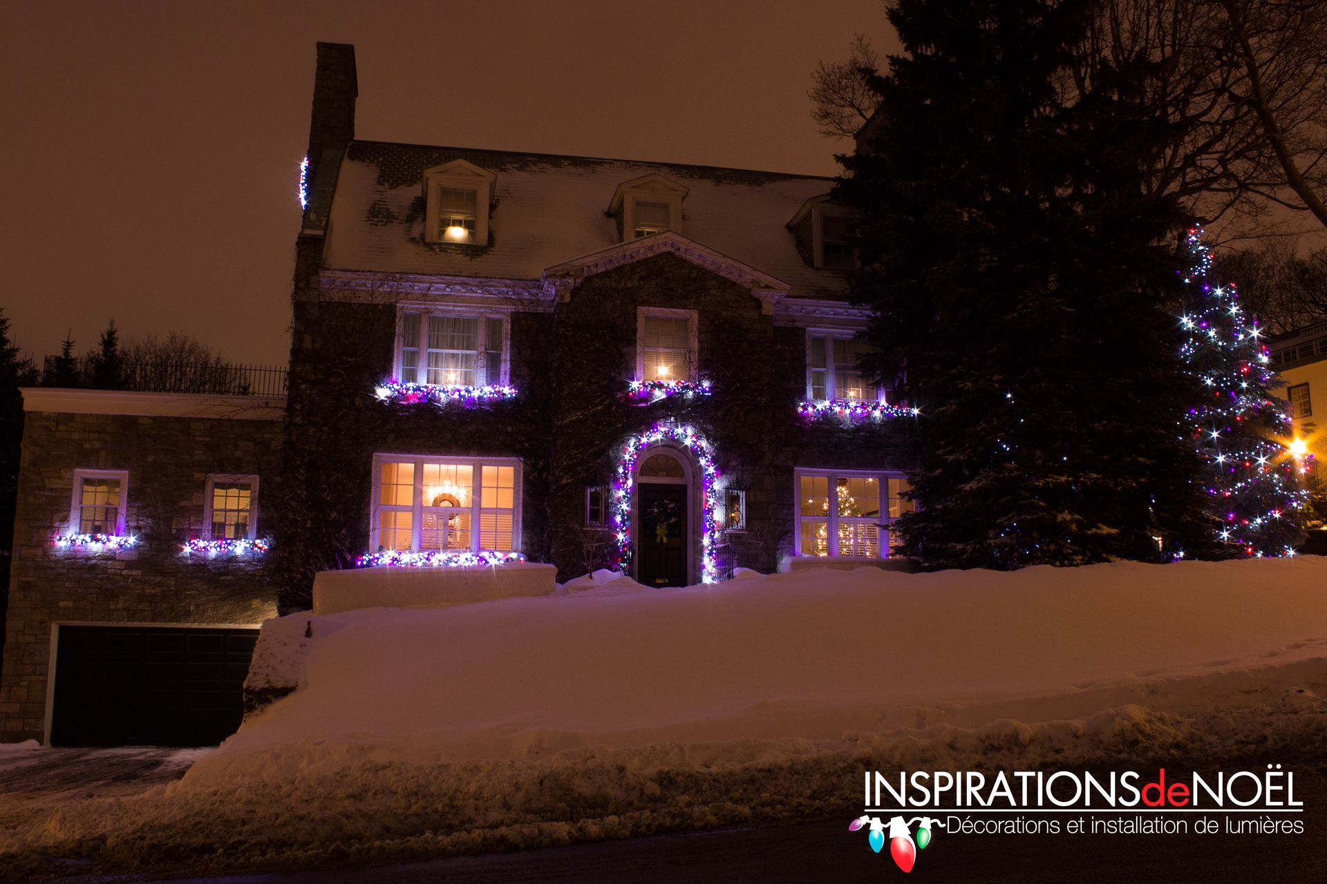 A house is decorated with christmas lights and a christmas tree