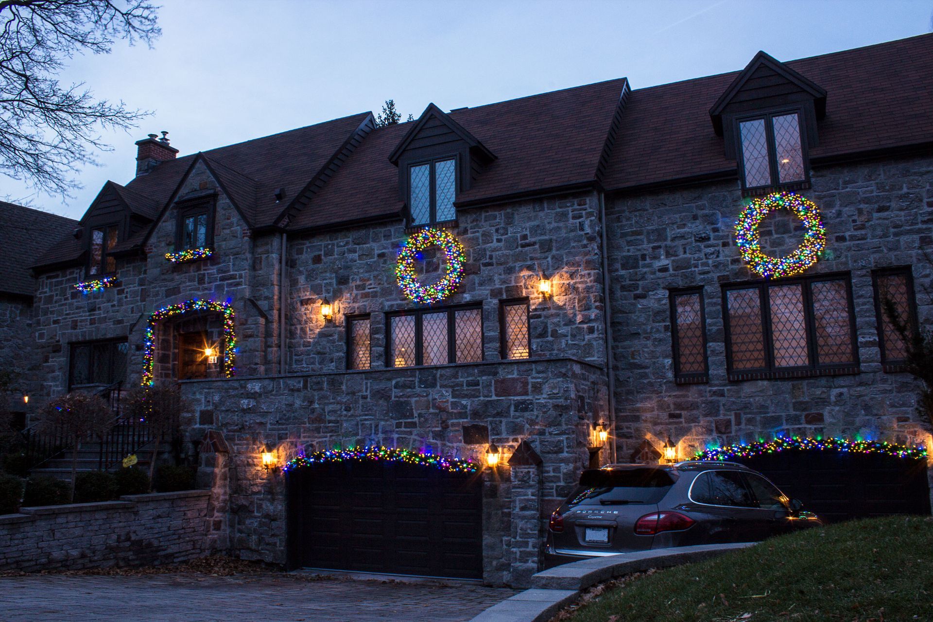 A large stone house decorated with christmas lights and wreaths