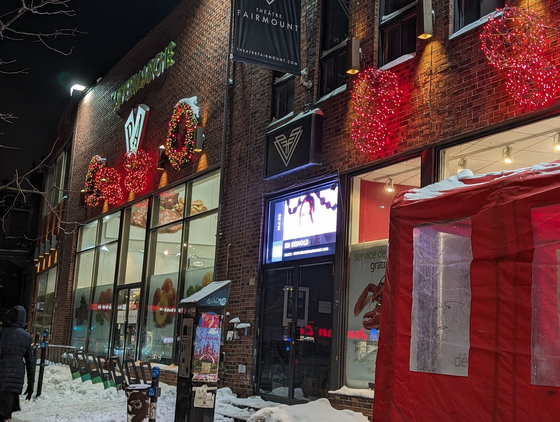 A brick building with a red tent in front of it