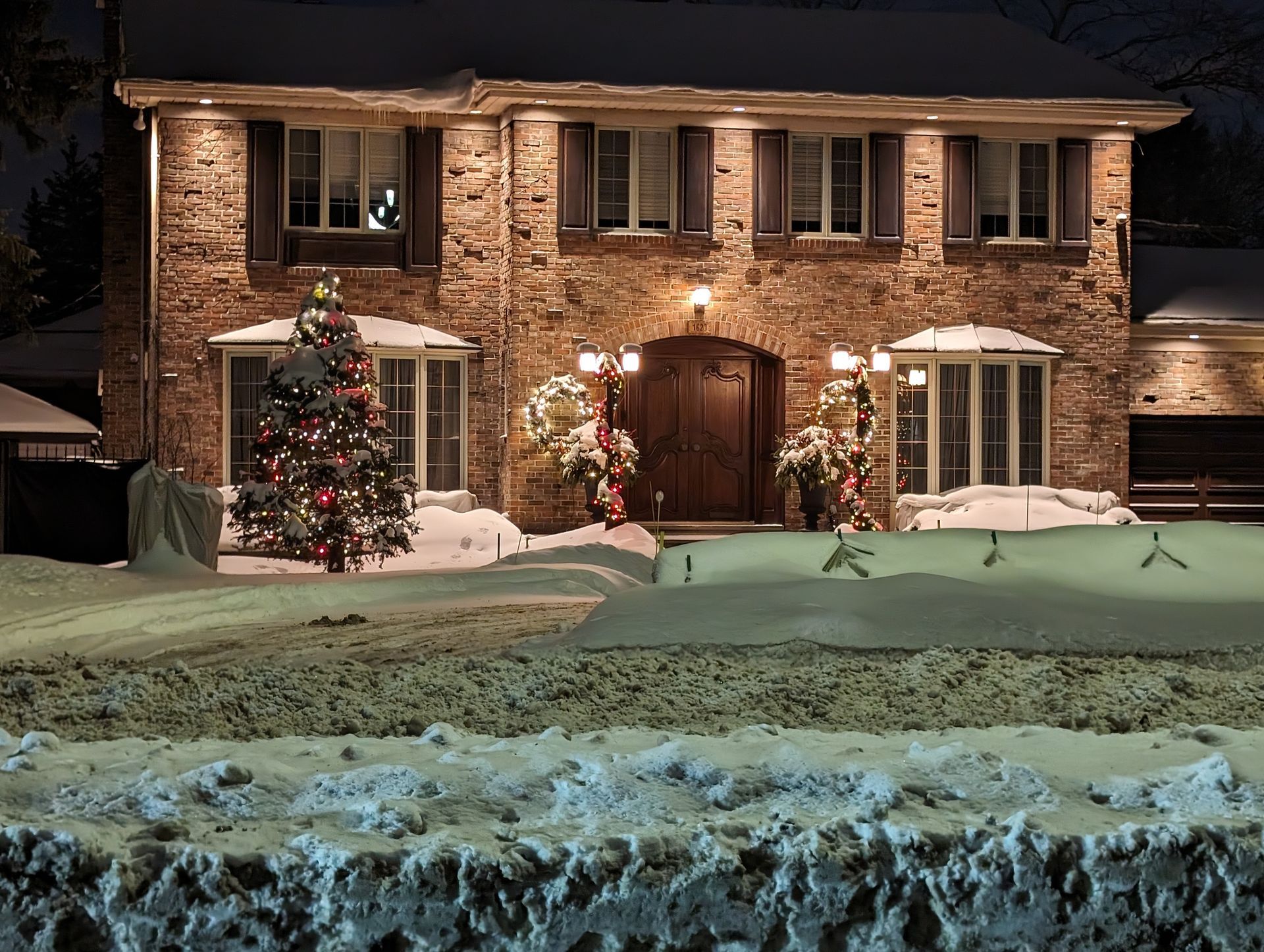 A brick house with a christmas tree in front of it