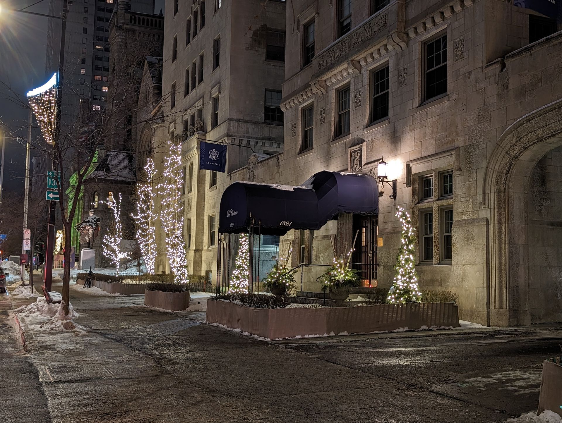 A building with a blue awning is lit up at night