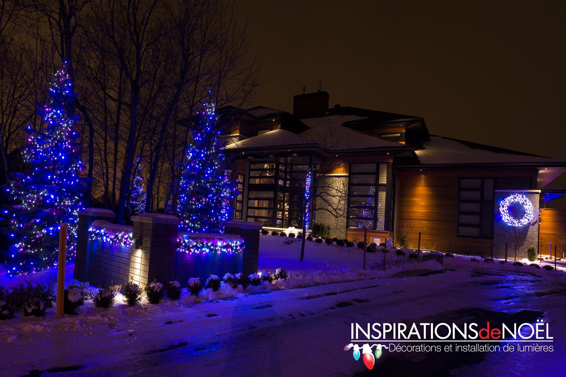 Une maison est décorée pour Noël avec des lumières bleues