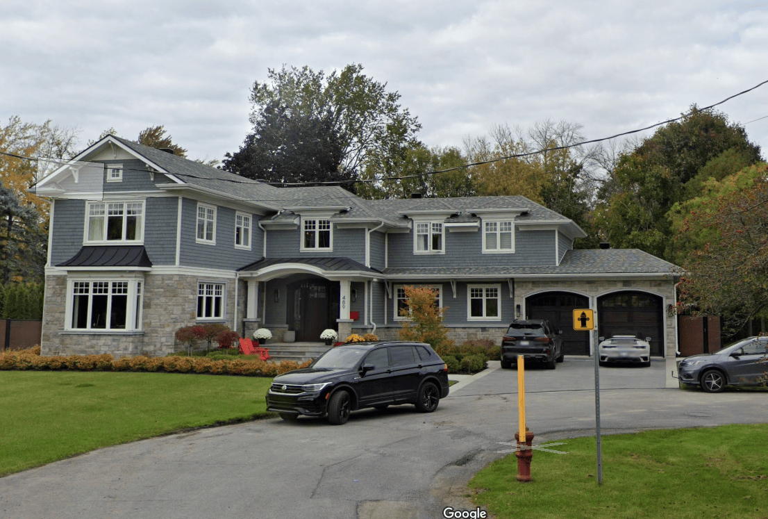 A large house with a car parked in front of it.