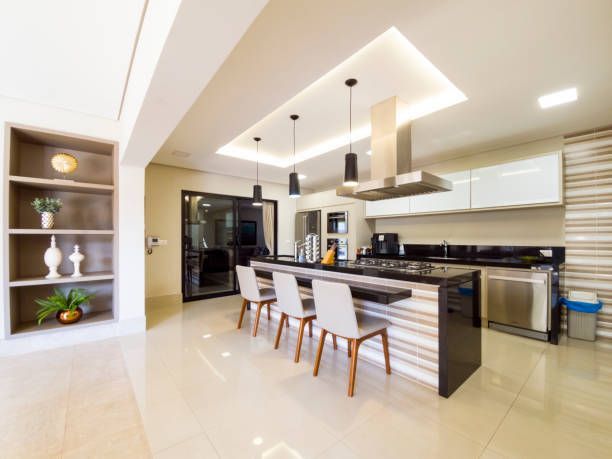Modern kitchen with island, white cabinets, black countertops, and pendant lights.