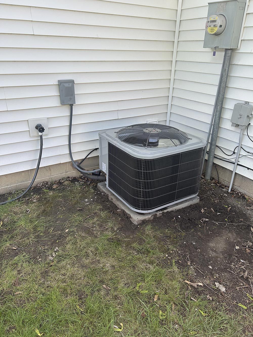 An air conditioner is sitting on the side of a house.