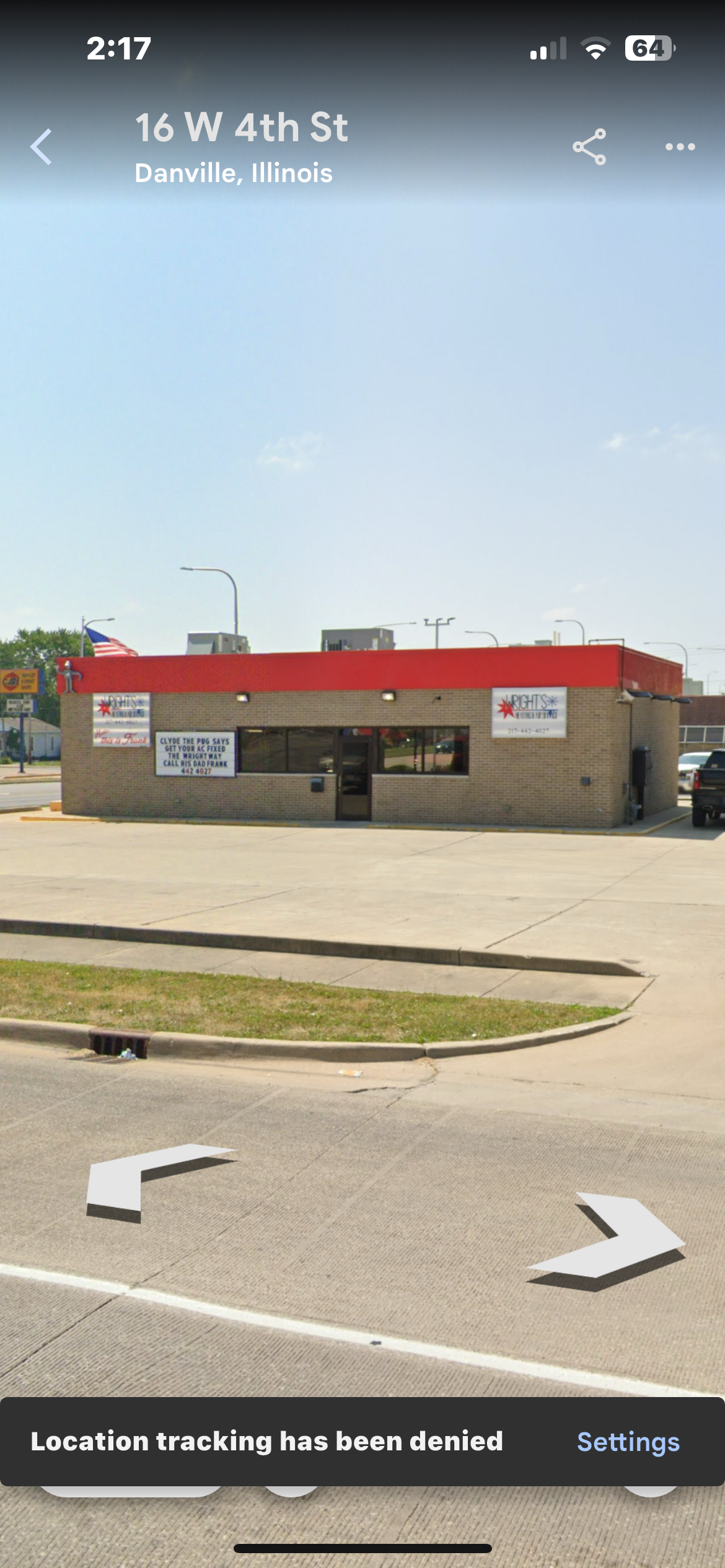 A building with a red roof is sitting on the side of the road.