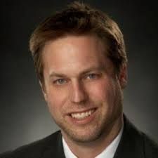 A man in a suit and tie is smiling for the camera.