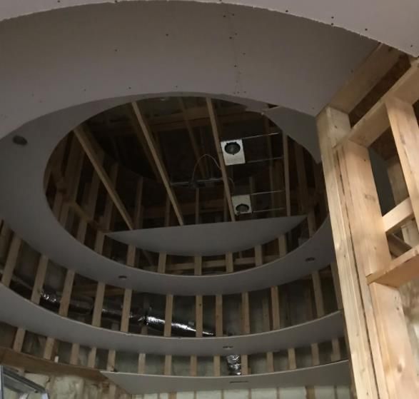 Interior construction, circular ceiling with exposed wooden framing and drywall.
