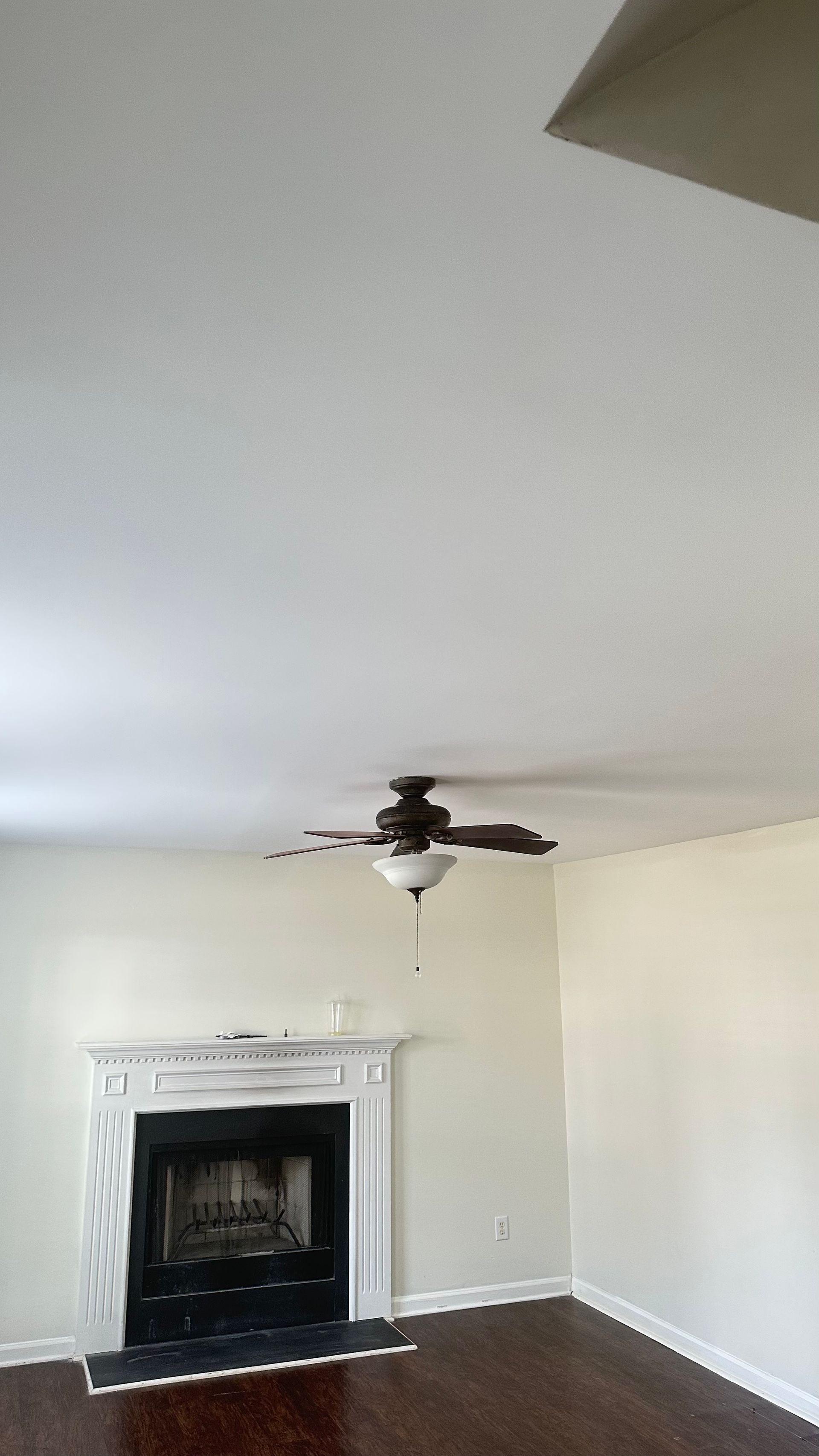 Living room with fireplace, dark hardwood floor, and a ceiling fan.