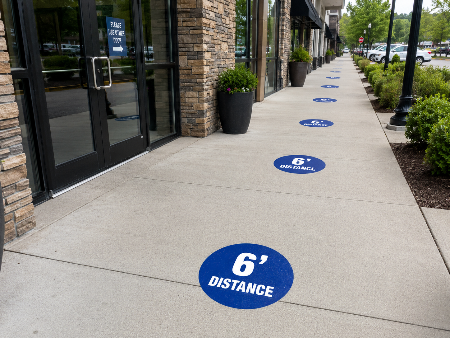 Sidewalk with blue 6-foot social distancing markers outside storefronts