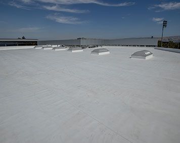 a white roof with a lot of skylights on it .